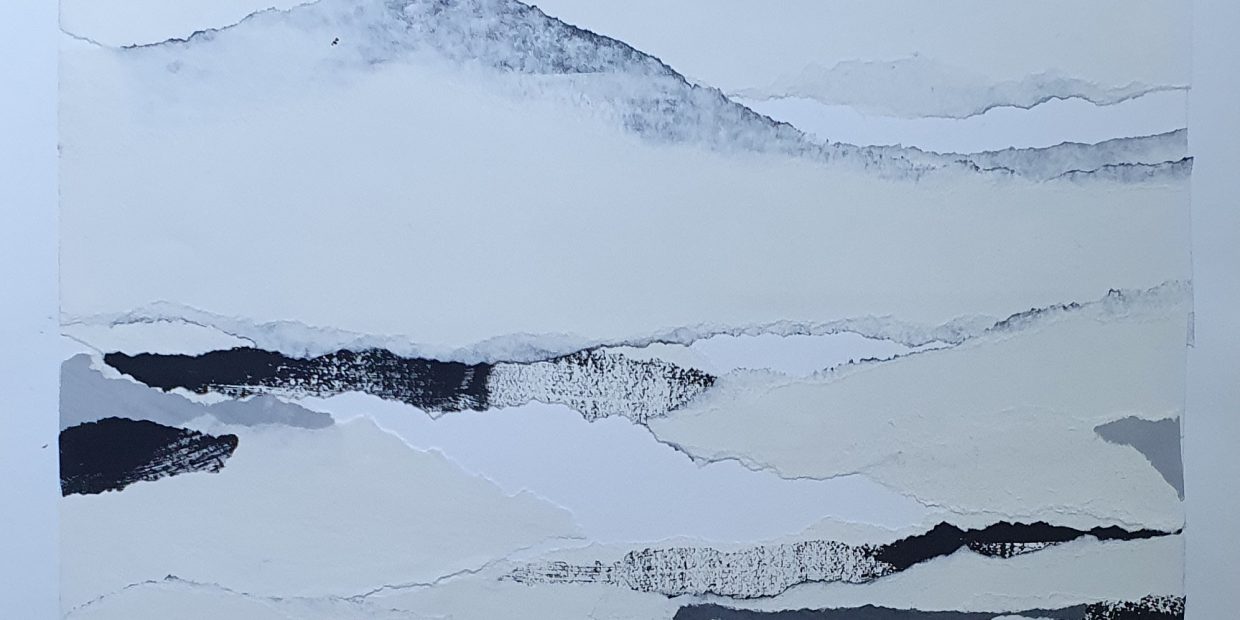 Papierkunstwerk in weiß-schwarz-grau-Tönen. Das Bild vermittelt einen ruhigen Eindruck von einer winterlich anmutenden Berglandschaft.